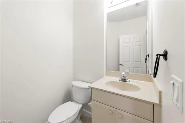 Bathroom vanity featuring an integrated sink with single-handle faucet, under-cabinet storage, and an overhead lighting fixture