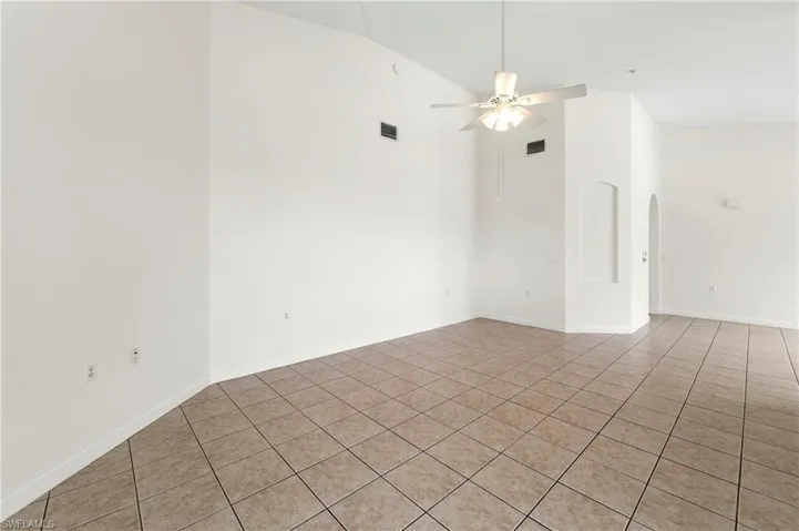 Expansive room with neutral tile flooring and white walls