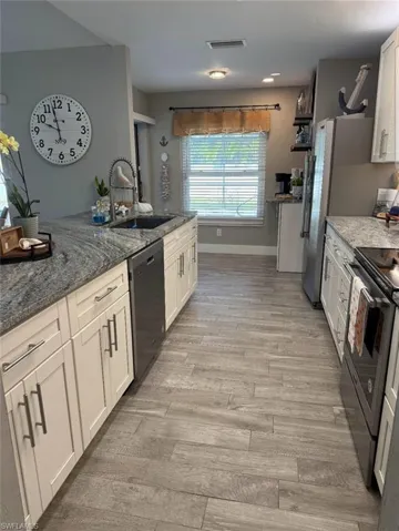 Kitchen and bar area leading out to pool area through glass sliders