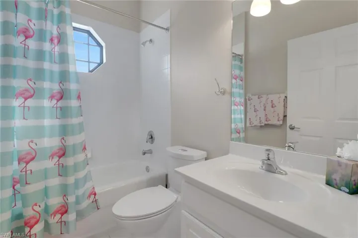 Full bathroom featuring vanity, shower / bath combination with curtain, and toilet