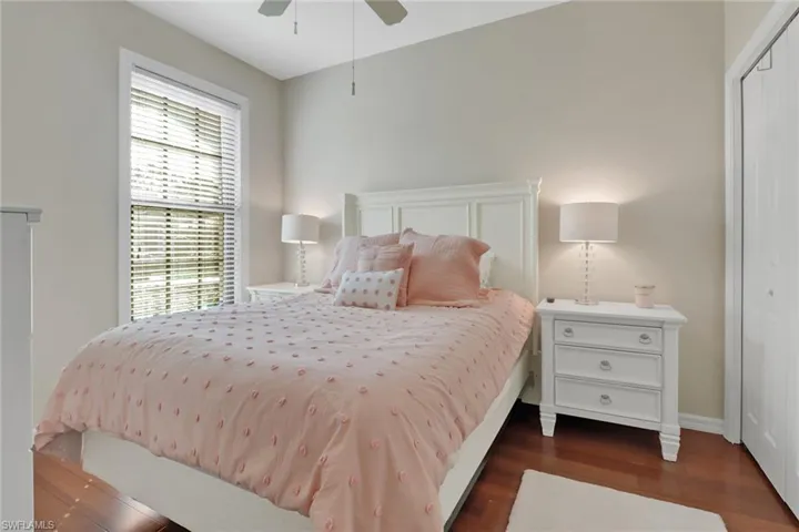 Bedroom featuring ceiling fan, dark hardwood / wood-style flooring, and a closet