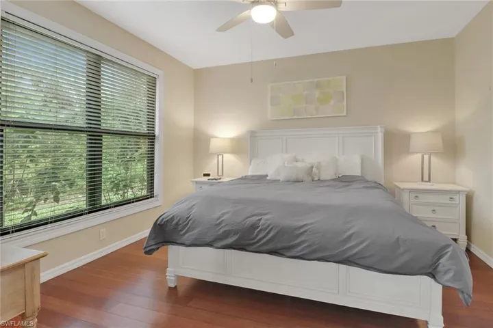Bedroom with dark hardwood / wood-style floors and ceiling fan