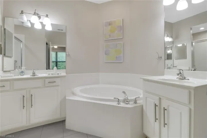 Bathroom featuring vanity, plus walk in shower, and tile patterned flooring