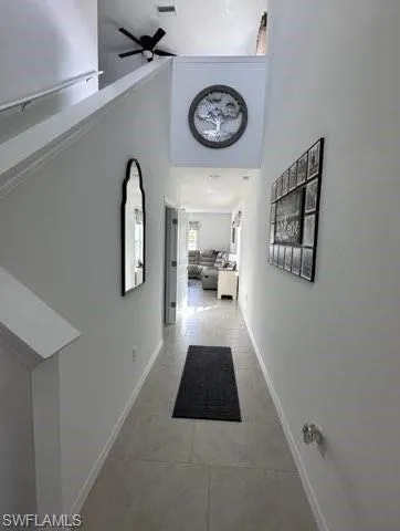 Corridor featuring a high ceiling and light tile patterned flooring