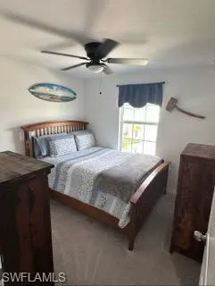 Carpeted bedroom featuring a ceiling fan
