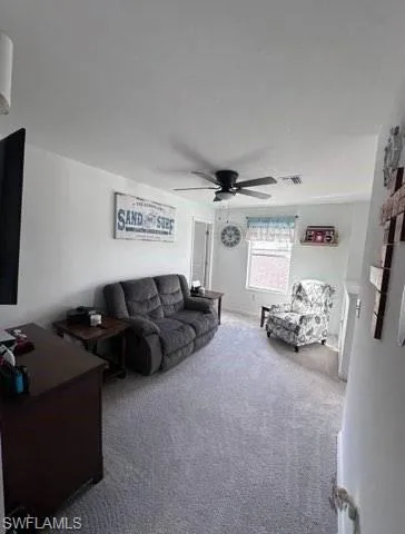 Living area with carpet and ceiling fan