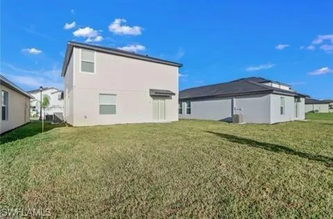 Rear view of property with a lawn