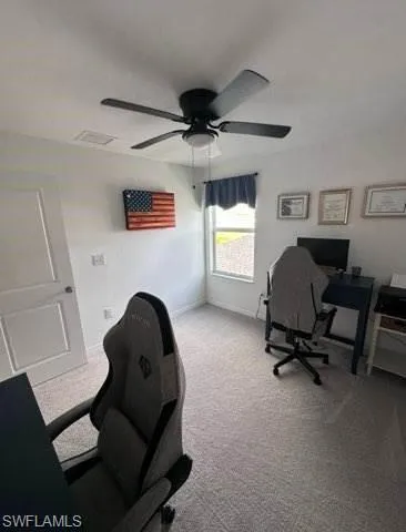 Office with light colored carpet and ceiling fan