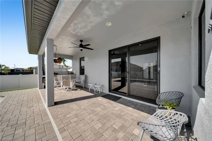 View of patio with outdoor dining space, a ceiling fan, and fence