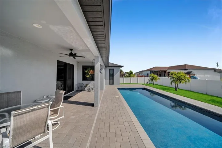 View of swimming pool with a yard, a ceiling fan, a fenced backyard, a patio, and a fenced in pool