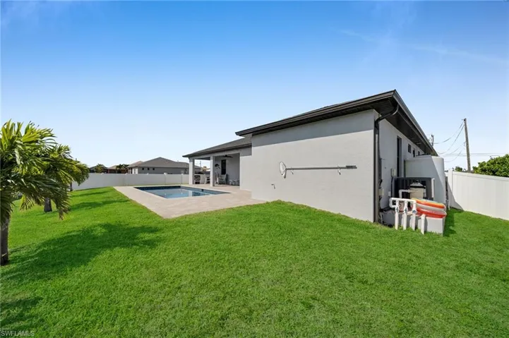Rear view of house with a patio area, a fenced backyard, a lawn, and stucco siding