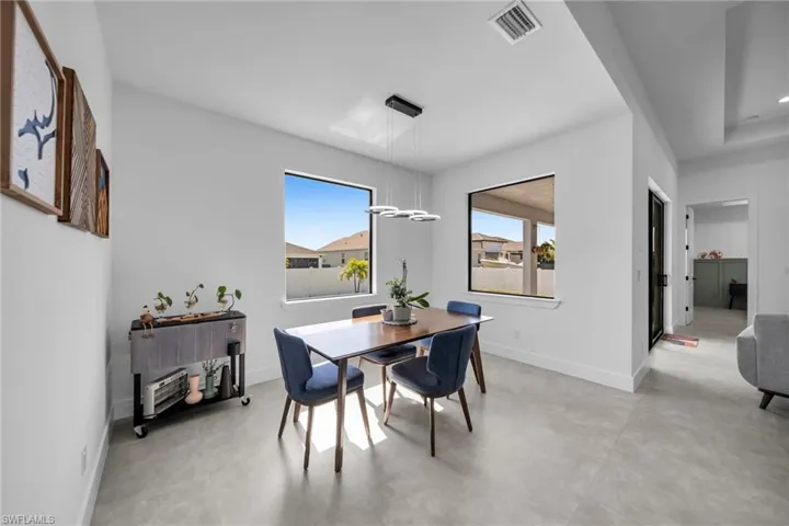 Dining space featuring visible vents, baseboards, and finished concrete floors