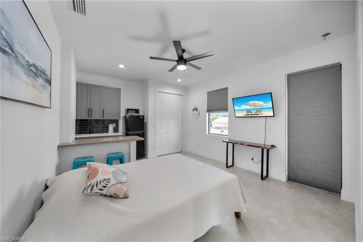 Bedroom with visible vents, baseboards, ceiling fan, freestanding refrigerator, and recessed lighting
