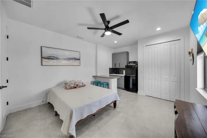 Bedroom featuring a closet, recessed lighting, freestanding refrigerator, a ceiling fan, and visible vents