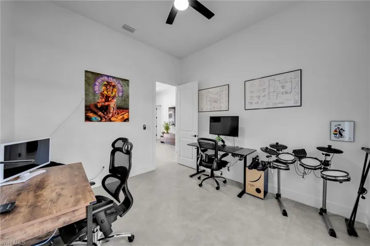 Office area featuring visible vents, baseboards, and a ceiling fan