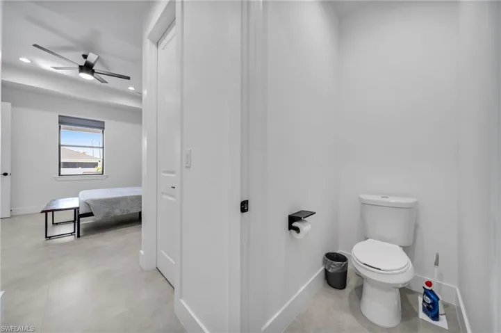 Bathroom featuring recessed lighting, baseboards, a ceiling fan, and toilet