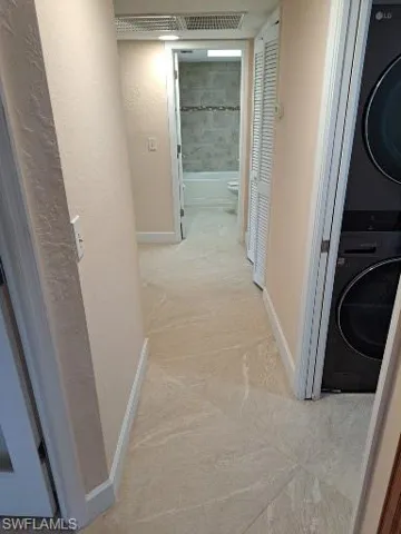 Hallway leading to 2nd bath, 3rd bedroom and laundry room with pocket door on right