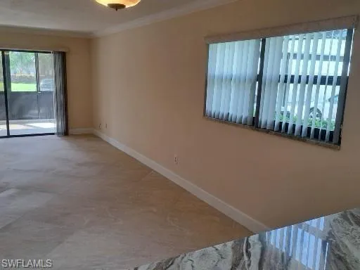 Living/Dining area with large tile and crown moulding