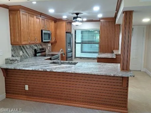 Kitchen with Granite back splash, ceiling fan, Granite counters, and stainless steel appliances