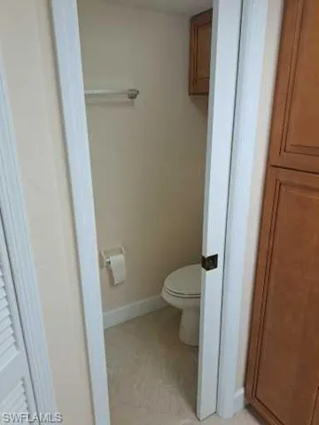 Bathroom featuring tile floors and toilet with pocket door for privacy