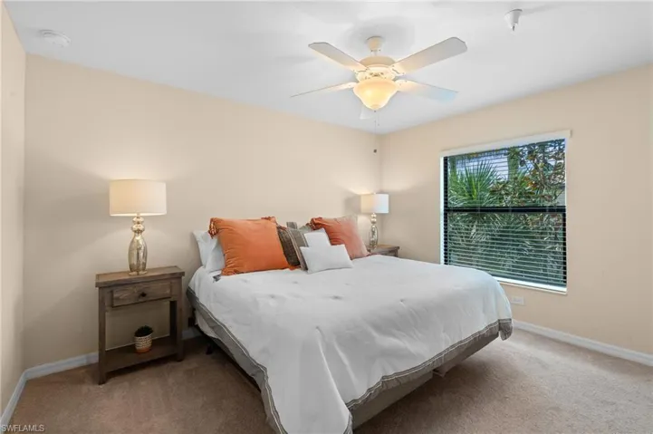 Bedroom with baseboards, ceiling fan, and light carpet