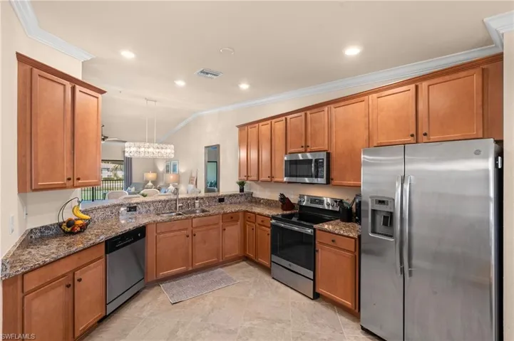 Kitchen featuring a sink, visible vents, brown cabinetry, and appliances with stainless steel finishes