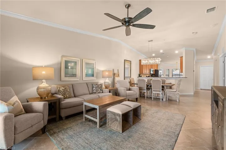 Living area with recessed lighting, ornamental molding, ceiling fan with notable chandelier, and visible vents