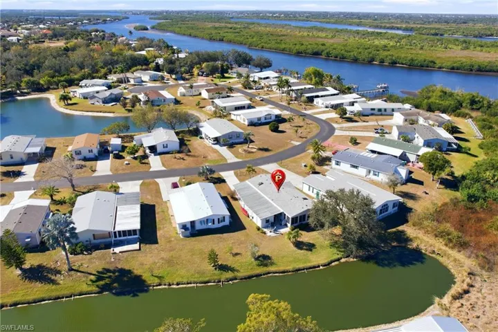 Aerial view of property's location with a nearby body of water and nearby suburban area