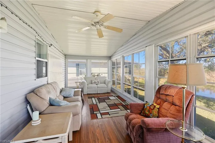 Sunroom with hardwood / wood-style floors, healthy amount of natural light, wooden walls, and a vaulted wood ceiling