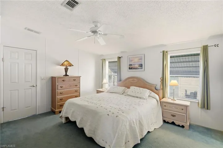 Bedroom featuring carpet floors, a ceiling fan, and a textured ceiling