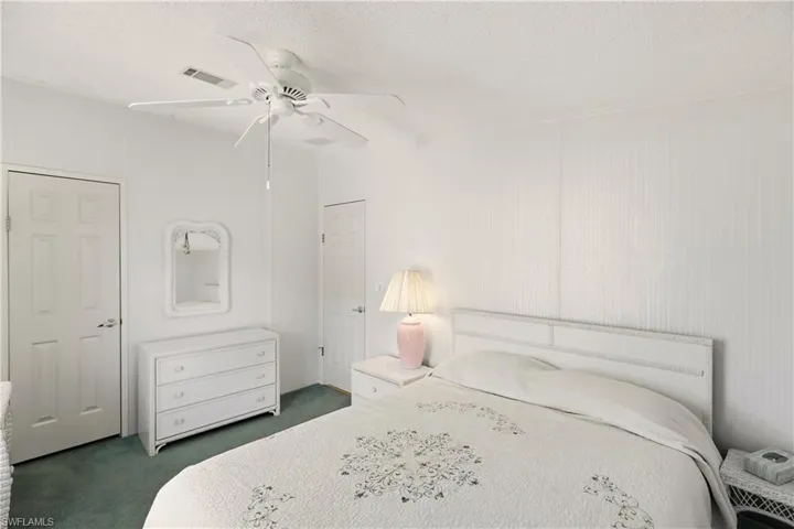 Bedroom featuring carpet, a textured ceiling, and a ceiling fan