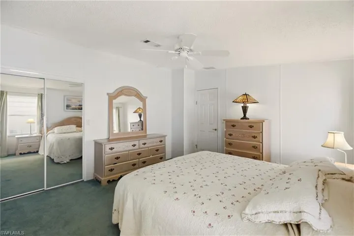 Carpeted bedroom with a textured ceiling, a closet, and ceiling fan
