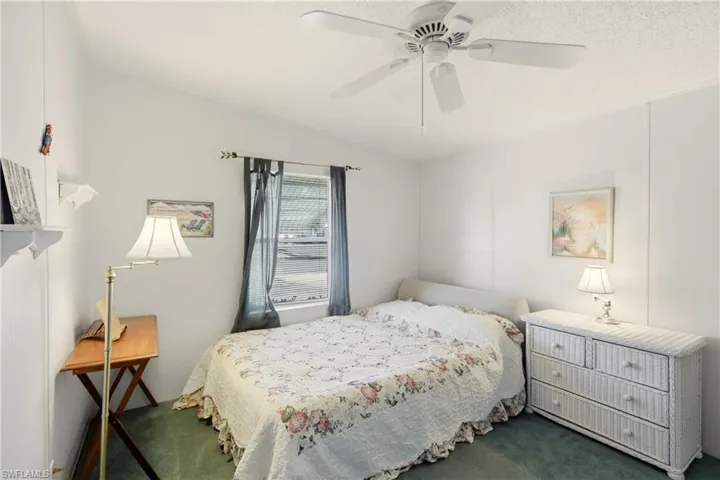 Carpeted bedroom with a ceiling fan