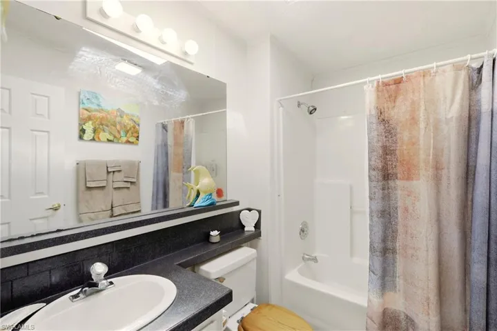 Full bathroom featuring vanity, shower / tub combo, and tasteful backsplash