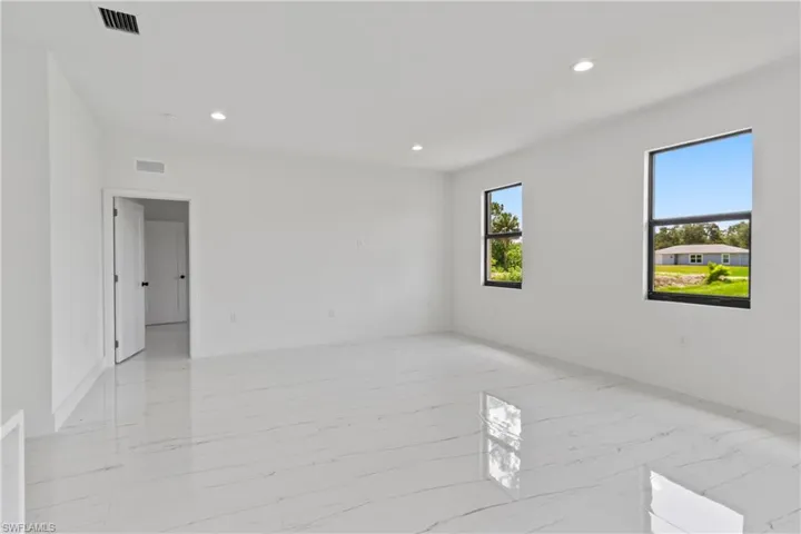 Unfurnished room featuring light marble finish flooring and recessed lighting