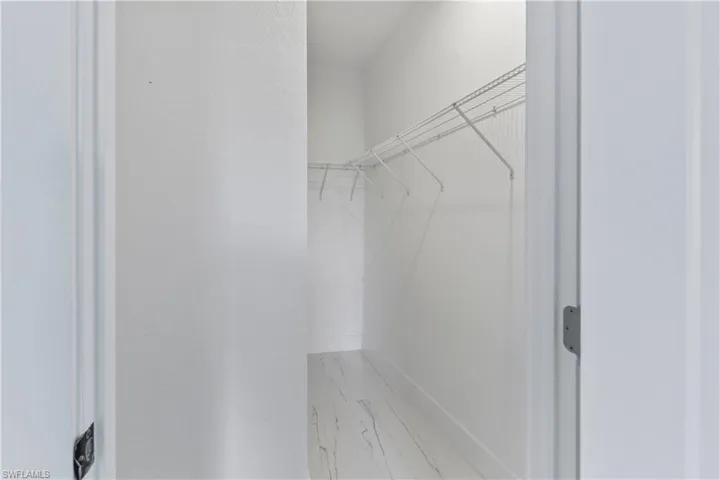 Walk in closet featuring marble finish floors