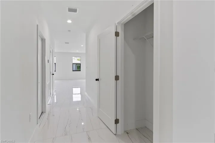 Corridor with marble finish flooring and recessed lighting