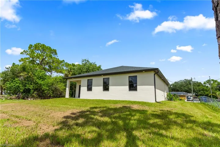 View of property exterior featuring stucco siding and a lawn