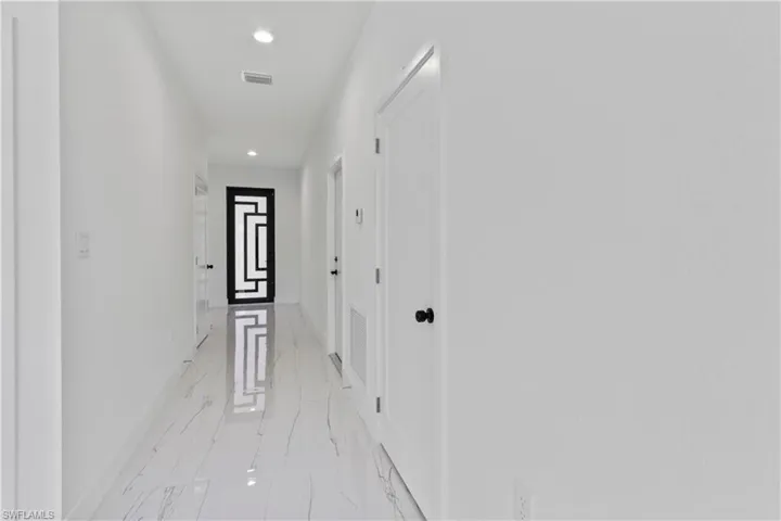 Hallway with recessed lighting and light marble finish floors