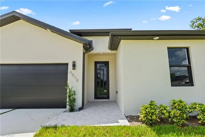 Property entrance with stucco siding and a garage