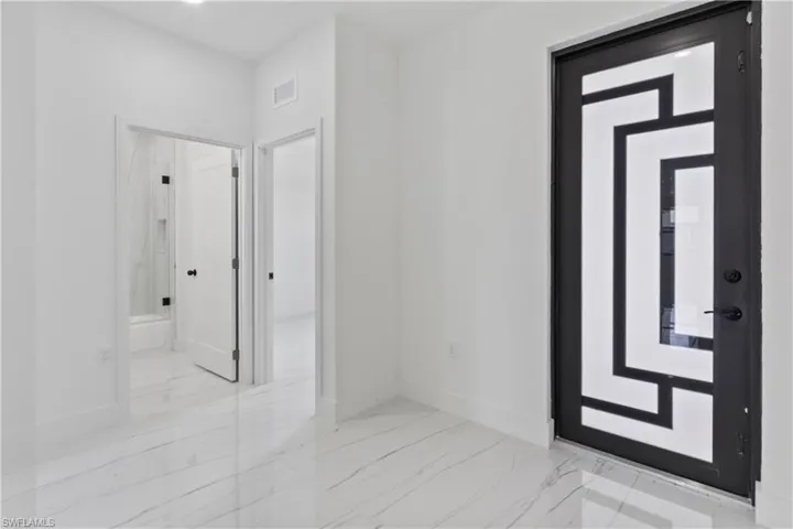 Entryway featuring marble finish floors and baseboards