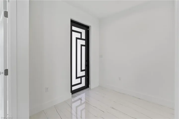 Entrance foyer with baseboards and light marble finish flooring