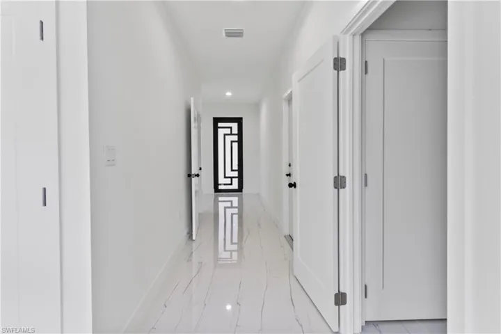 Corridor featuring recessed lighting and light marble finish floors
