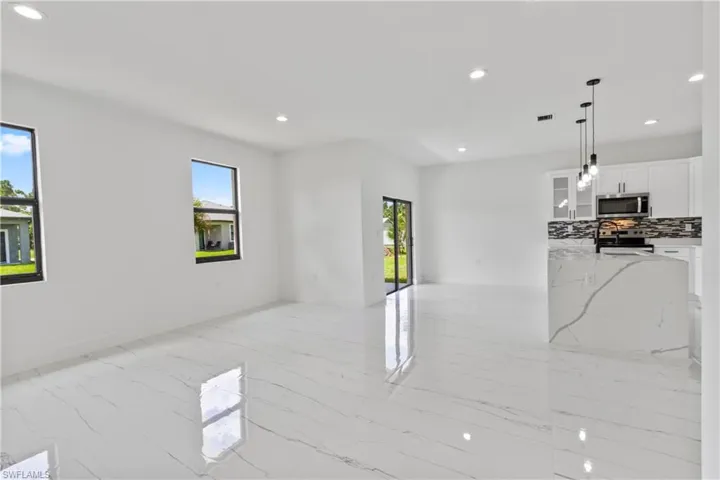 Unfurnished living room with recessed lighting and light marble finish floors