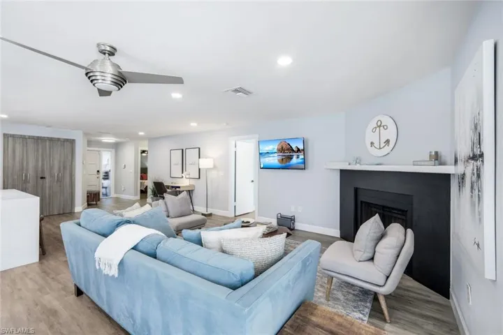 Living room with ceiling fan and hardwood / wood-style floors
