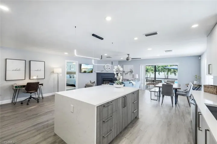 Kitchen featuring decorative light fixtures, ceiling fan, a kitchen island, and light hardwood / wood-style flooring