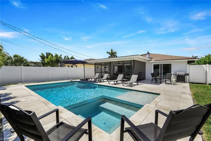 View of pool with an in ground hot tub, a patio area, and grilling area