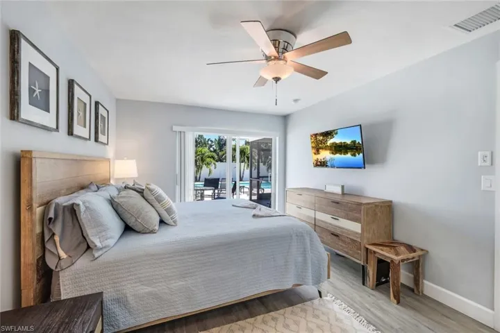 Bedroom featuring hardwood / wood-style floors, ceiling fan, and access to outside