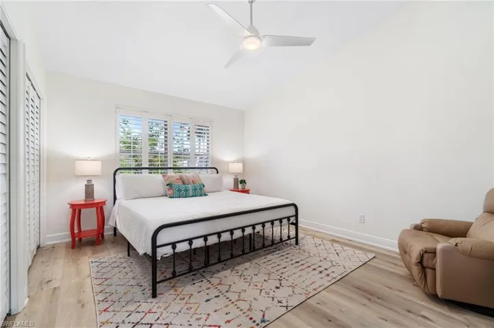 Bedroom with lofted ceiling, light wood-style flooring, and ceiling fan