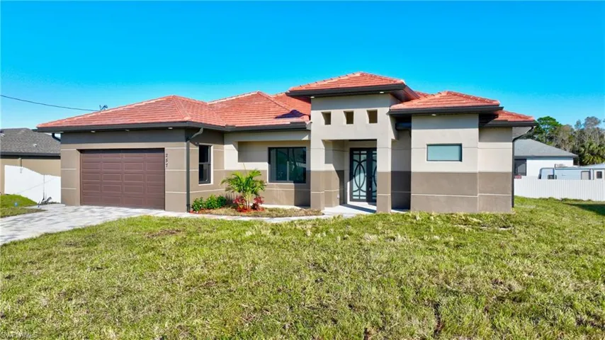 View of front of house featuring a front lawn and a garage